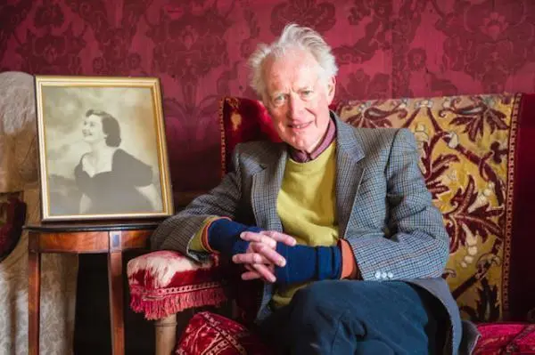 Bamber Gascoigne sitting in a chair